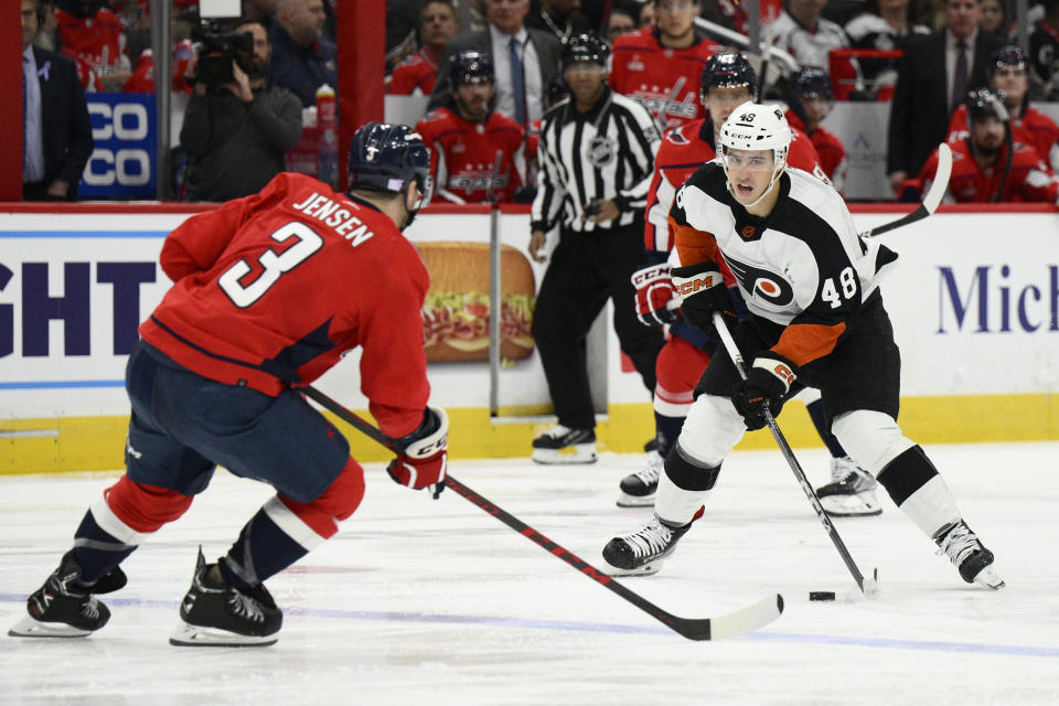 Philadelphia Flyers center Morgan Frost (48) skates with the puck against Washington Capitals defenseman Nick Jensen (3) during the second period of an NHL hockey game, Wednesday, Nov. 23, 2022, in Washington. (AP Photo/Nick Wass)