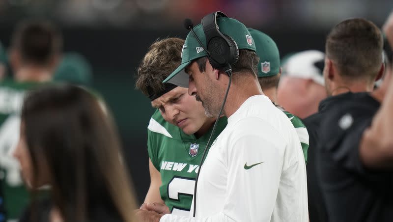 New York Jets quarterbacks Aaron Rodgers, right, and Zach Wilson talk during a preseason NFL football game against the Tampa Bay Buccaneers, Saturday, Aug. 19, 2023, in East Rutherford, N.J. 