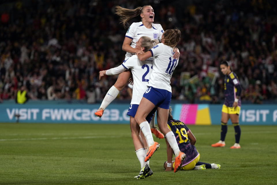 England's Alessia Russo , center, is celebrated after she scored her side's second goal during the Women's World Cup quarterfinal soccer match between England and Colombia at Stadium Australia in Sydney, Australia, Saturday, Aug. 12, 2023. (AP Photo/Mark Baker)