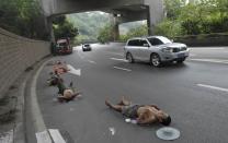 RNPS - PICTURES OF THE YEAR 2013 - Labourers who work nearby nap on a road as cars drive past in Chongqing Municipality, July 23, 2013. REUTERS/Stringer (CHINA - Tags: SOCIETY TPX) CHINA OUT. NO COMMERCIAL OR EDITORIAL SALES IN CHINA