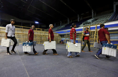FILE PHOTO: Members of election staff carry Electronic Voting Machines (EVM) and Voter Verifiable Paper Audit Trail (VVPAT) machines after collecting them from a distribution centre at an indoor stadium ahead of the seventh and last phase of general election, in Kolkata, May 18, 2019. REUTERS/Rupak De Chowdhuri/File Photo