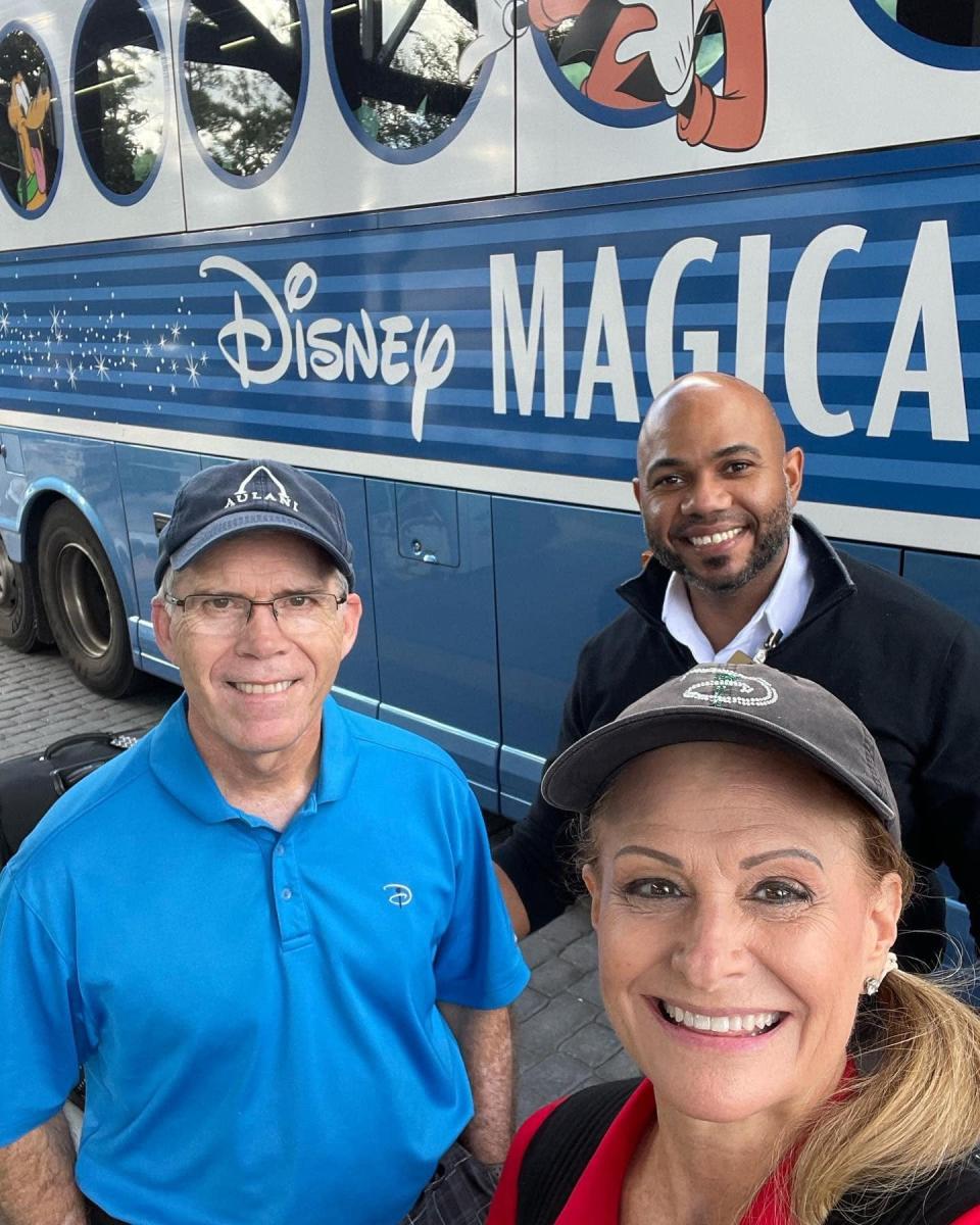 Bill and Pamela Skaar of Grand Prairie, Texas, foreground, are joined by a Magical Express driver, Edwin,  after the couple's last journey on a Magical Express bus from a Walt Disney World resort to Orlando International Airport. The popular free service, between the airport and Disney resorts, ended in early January.