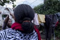 Mother of two Amsale Hailemariam, left, a domestic worker who lost work because of the coronavirus, hangs washing on the line with her daughter, Bethlehem Jafar, outside her tent in the capital Addis Ababa, Ethiopia on Friday, June 26, 2020. Bethlehem was forced home from her studies as school closed and now shelters with her mother. (AP Photo/Mulugeta Ayene)