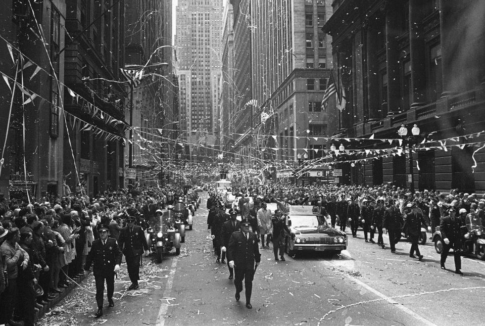 FILE - In this May 1, 1970 file photo, confetti falls from the skyscrapers in Chicago's financial district as Apollo 13 astronauts John Swigert and Jim Lovell ride in a motorcade during a parade in their honor. (AP Photo)