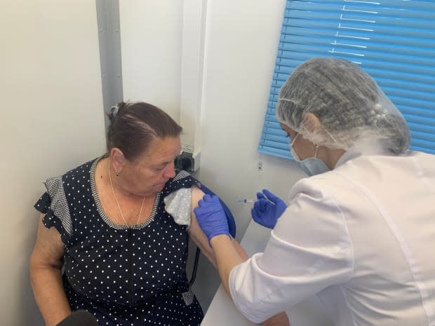 A woman gets a shot of COVID-19 vaccine in a mobile clinic outside Moscow. In five hours that CBC News was there, the mobile clinic team vaccinated only seven people.