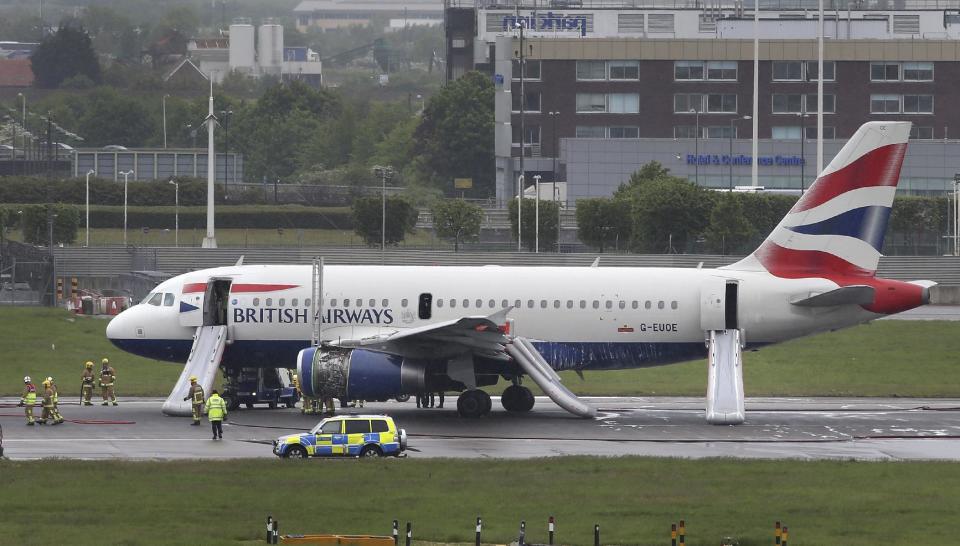 Emergency services attend a British Airways passenger plane after it had to make an emergency landing at Heathrow airport. early Friday May 24, 2013. Both runways at Heathrow airport were closed after a British Airways plane had to make an emergency landing, and Heathrow said that all passengers and crew had been safely evacuated from the plane following the incident. Footage broadcast on British television shows the plane in the air with smoke streaming from one engine. (AP Photo/Steve Parsons, PA) UNITED KINGDOM OUT - NO SALES - NO ARCHIVES