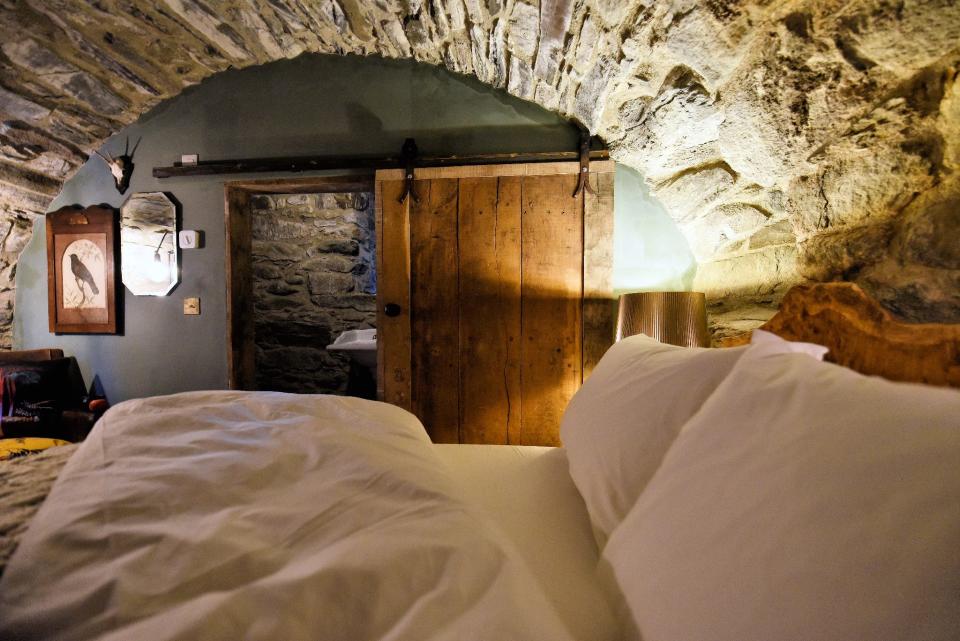 One of the rooms at Kilmartin Castle, where the bed is tucked into a double vaulted exposed stone ceiling.