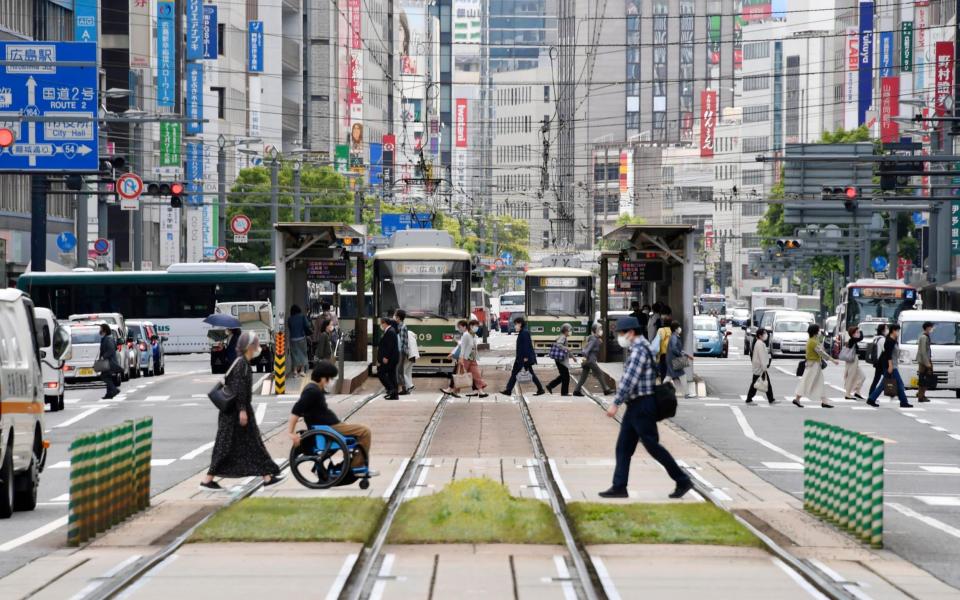 People wearing face masks make their way in Hiroshima, western Japan, - Kyodo News