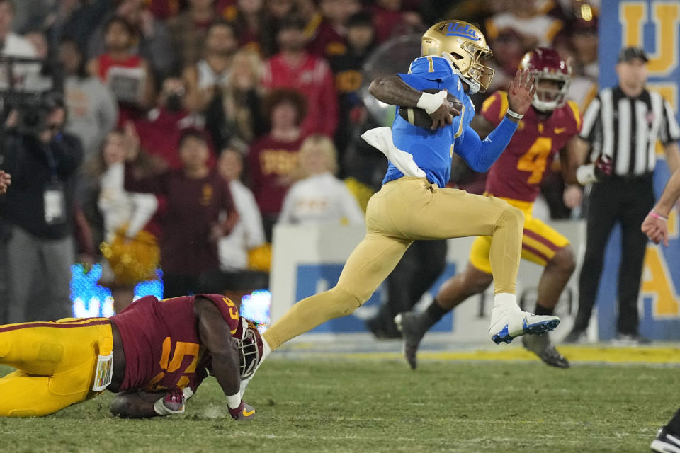 UCLA quarterback Dorian Thompson-Robinson, right, escapes a tackle by Southern California linebacker Shane Lee during the second half of an NCAA college football game Saturday, Nov. 19, 2022, in Pasadena, Calif. (AP Photo/Mark J. Terrill)