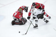 Los Angeles Kings' Kevin Fiala (22) handles the puck as Chicago Blackhawks goaltender Petr Mrazek (34) and Jarred Tinordi defend during the second period of an NHL hockey game Friday, March 15, 2024, in Chicago. Mrazek was called for slashing on the play. (AP Photo/Charles Rex Arbogast)