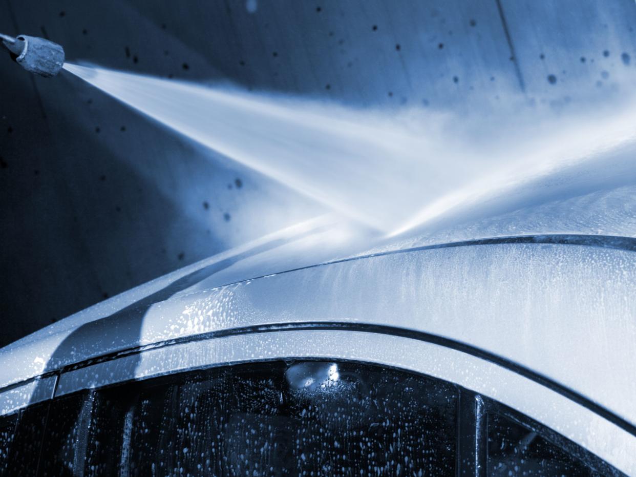 Washing car by a water jet at a carwash service