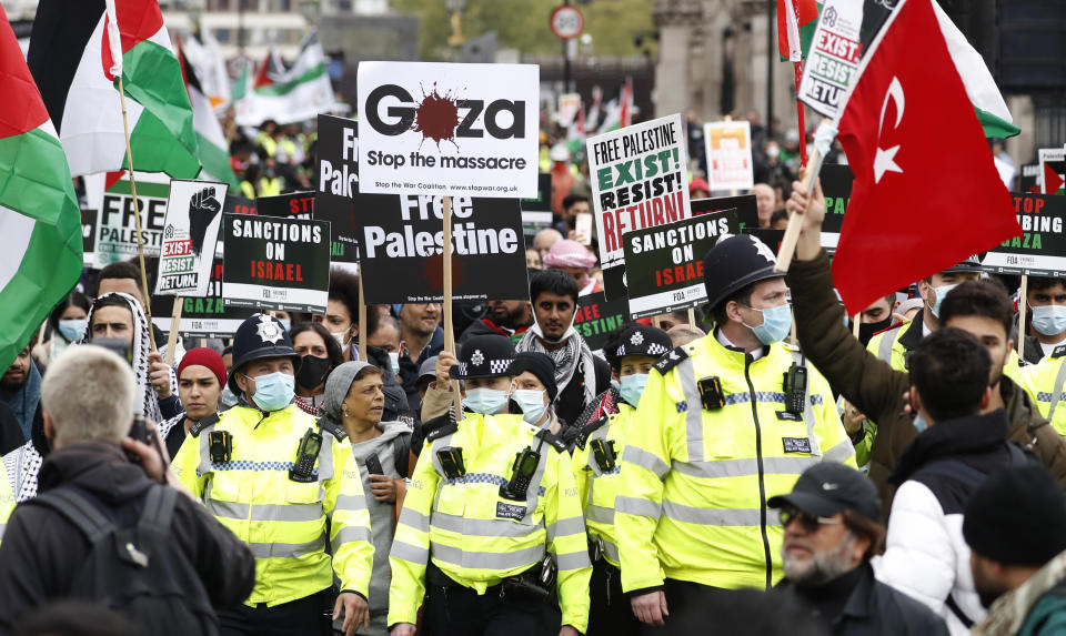 Protesters hold placards and banners in London, Saturday, May 22, 2021, as they take part in a rally supporting Palestinians. Egyptian mediators held talks Saturday to firm up an Israel-Hamas cease-fire as Palestinians in the Hamas-ruled Gaza Strip began to assess the damage from 11 days of intense Israeli bombardment. (AP Photo/Alastair Grant)