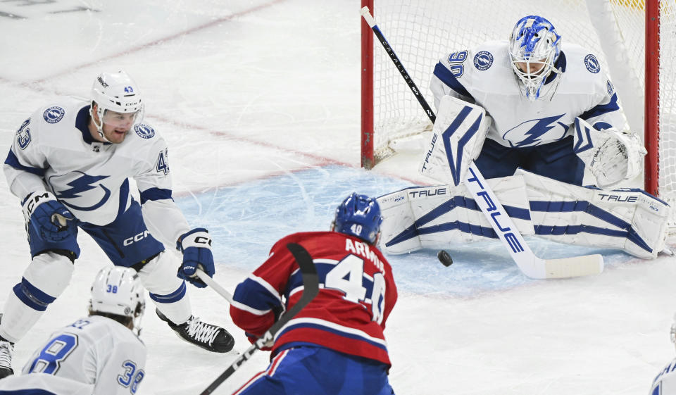 Montreal Canadiens' Joel Armia (40) scores against Tampa Bay Lightning goaltender Matt Tomkins as Lightning's Darren Raddysh (43) defends during the second period of an NHL hockey game Thursday, April 4, 2024, in Montreal. (Graham Hughes/The Canadian Press via AP)