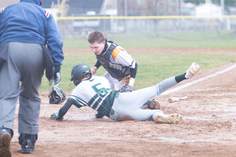 Pennfield sophomore Garrett Hill slides into home plate during a game at Battle Creek Central High School on Thursday, April 4, 2024.