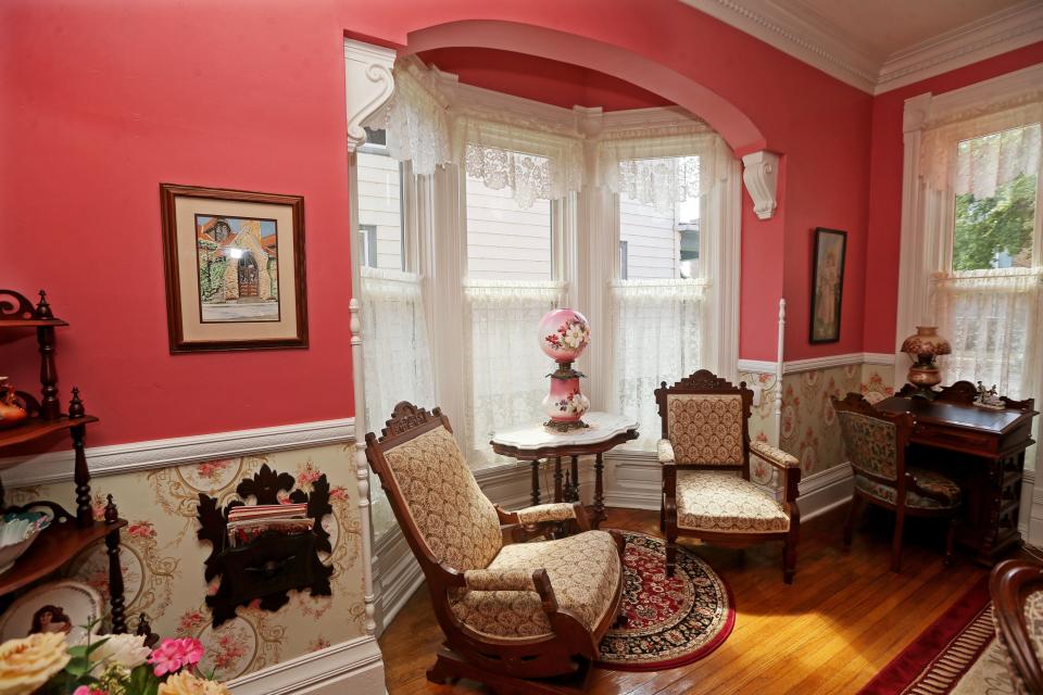 A bay window in the formal dining room is a perfect setting for a pair of 1890s  Victorian Eastlake chairs at the home of Bill Hansen and Bob Groth.