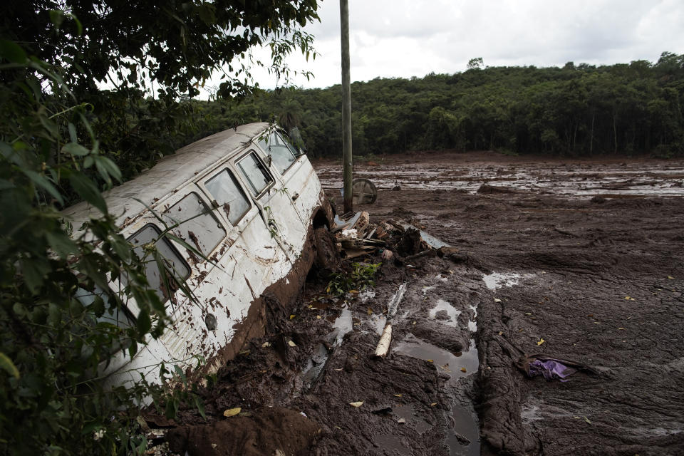 A van is seen in half buried in the mud after a dam collapse near Brumadinho, Brazil, Saturday, Jan. 26, 2019. Rescuers in helicopters on Saturday searched for survivors while firefighters dug through mud in a huge area in southeastern Brazil buried by the collapse of a dam holding back mine waste, with at least nine people dead and up to 300 missing. (AP Photo/Leo Correa)