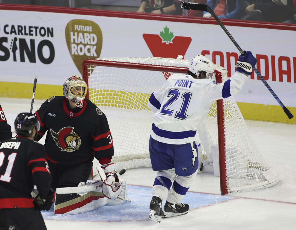 Tampa Bay Lightning's Brayden Point (21) celebrates after scoring his third goal, as Ottawa Senators goaltender Anton Forsberg (31) looks over during the third period of an NHL hockey game Saturday, Nov. 4, 2023, in Ottawa, Ontario. (Patrick Doyle/The Canadian Press via AP)