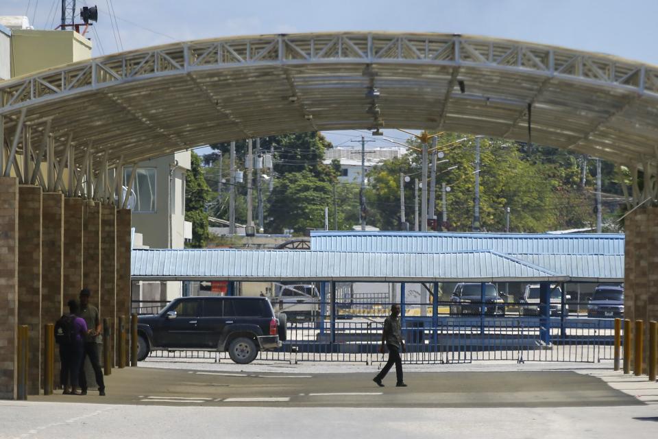 People stand in a courtyard at the international airport in Port-au-Prince, Haiti, Monday, March 4, 2024. Authorities ordered a 72-hour state of emergency starting Sunday night following violence in which armed gang members overran the two biggest prisons and freed thousands of inmates over the weekend. (AP Photo/Odelyn Joseph)