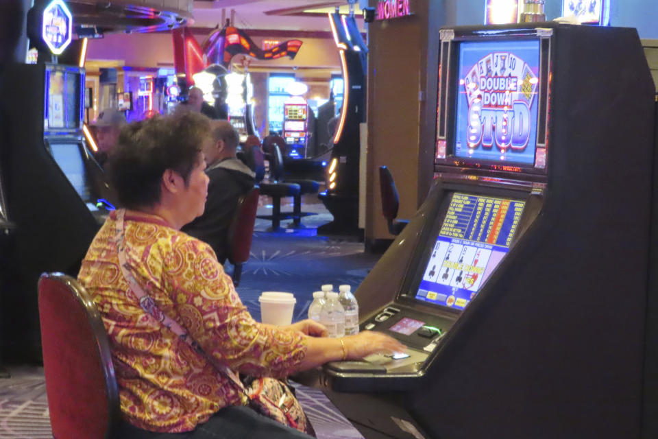 A gambler plays a slot machine at Harrah's casino in Atlantic City N.J. on Sept. 29, 2023. Atlantic City faces challenges in the new year including a potential smoking ban in its nine casinos, and their quest to return to pre-pandemic business levels. (AP Photo/Wayne Parry)