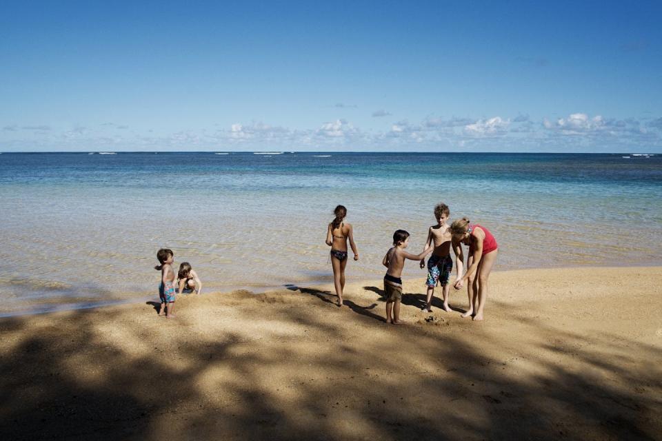 Mom and five kids at the beach.