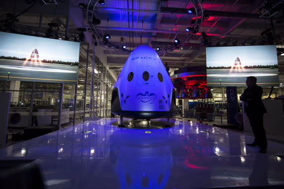 SpaceX CEO Elon Musk stands near the company's Dragon V2 manned space capsule during its public unveiling on May 29, 2014. The seven-person Dragon V2 space capsule is SpaceX's entry to fly NASA astronauts to the International Space Station.