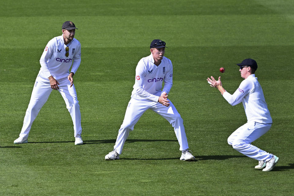 England's Harry Brook, right, takes a catch to dismiss New Zealand's Henry Nicholls as England teammates Joe Root, left, and Zak Crawley watch on day 4 of their cricket test match in Wellington, New Zealand, Monday, Feb 27, 2023. (Andrew Cornaga/Photosport via AP)