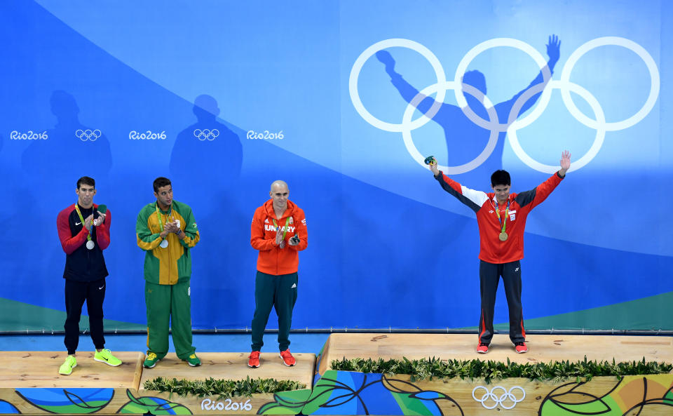 RIO DE JANEIRO, BRAZIL - AUGUST 12: (R-L) Joint silver medalists, Michael Phelps of United States, Chad Guy Bertrand le Clos of South Africa, Laszlo Cseh of Hungary and gold medalist Joseph Schooling of Singapore celebrate on the podium during the medals ceremony in the Men's 100m Butterfly Final on Day 7 of the Rio 2016 Olympic Games at the Olympic Aquatics Stadium on August 12, 2016 in Rio de Janeiro, Brazil.  (Photo by Richard Heathcote/Getty Images)