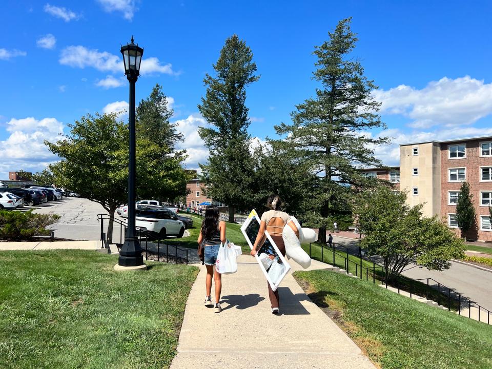 On her way to set up her new dorm room, new College of the Holy Cross student gets help from her younger sister