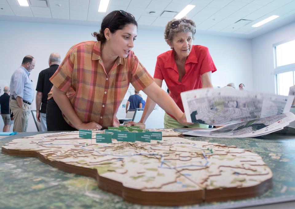 Sophie Riedel, SCAPE senior designer and watershed management team, left, and Blair Stephenson, president of the Bayou Texar Association, discuss some of the potential projects to restore the health of Carpenter Creek during an open house at the Bayview Community Center in Pensacola on Monday, May 2, 2022.