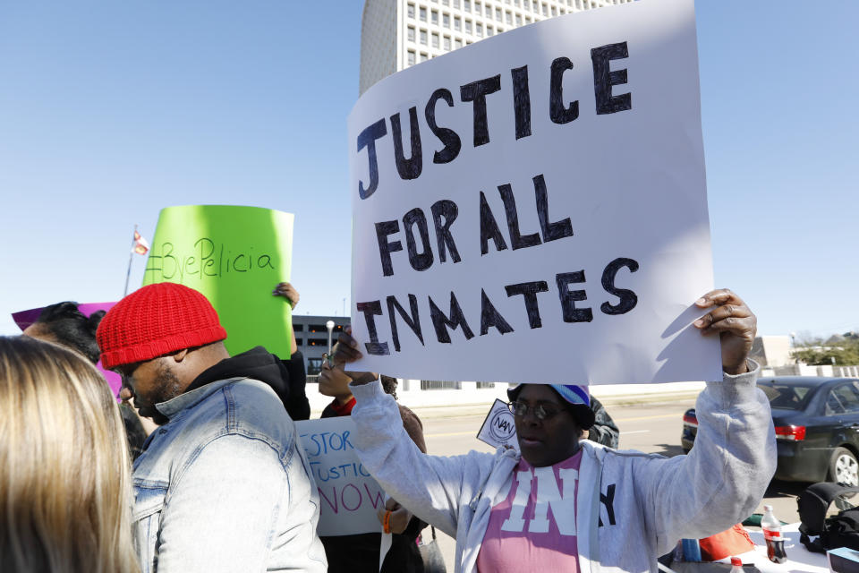 Prisoner advocates hold signs supporting inmate rights at a protest outside the Capitol in Jackson, Miss., Tuesday, Jan. 7, 2020. The protesters called on the federal government to investigate Mississippi's prison system for possible civil rights violations. They say five deaths in recent days highlights deliberate violations of inmates' constitutional rights. (AP Photo/Rogelio V. Solis)