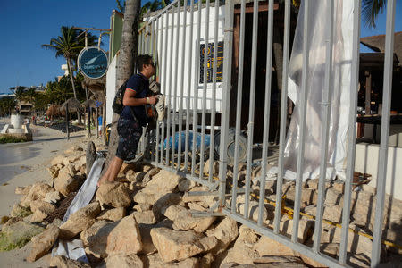 A man looks through a fence of the Blue Parrot nightclub after a gunman opened fire early Monday outside the venue, killing several people and injuring others during a BPM electronic music festival, according to a statement of the organizers, in Playa del Carmen, Mexico January 16, 2017. REUTERS/Stringer