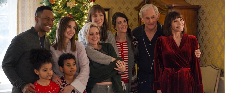 A group of people pose for a photo in front of a decorated tree.