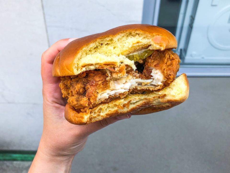 A hand holding a Burger King fried-chicken sandwich.