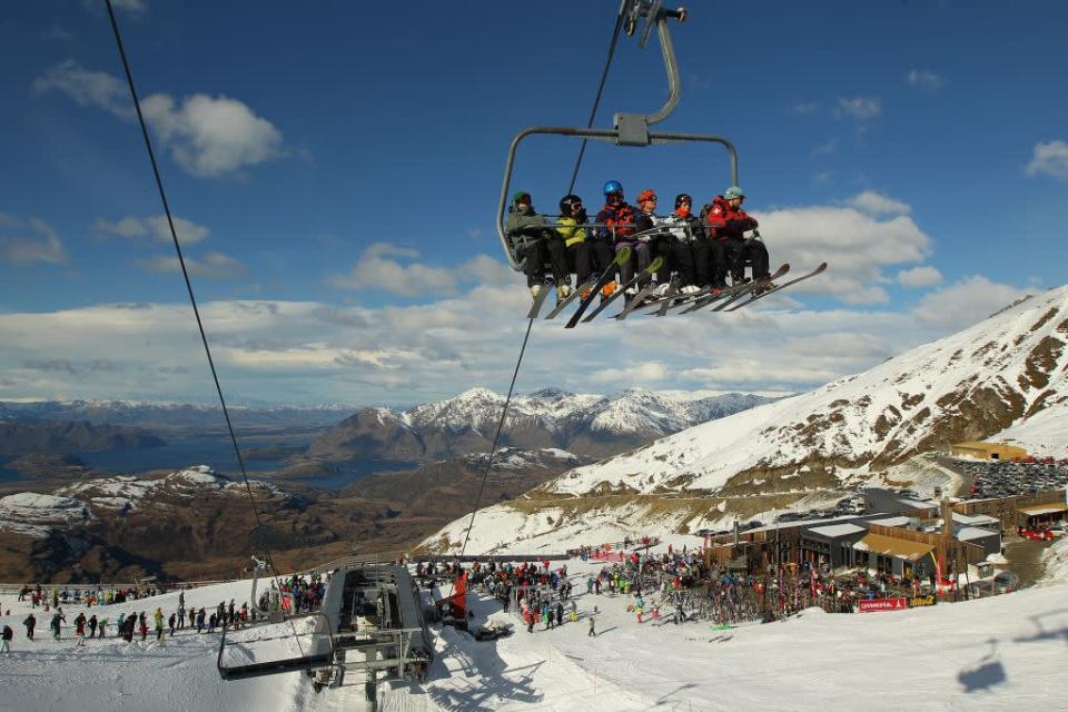 Skiiers ride a chairlift at Treble Cone ski resort in Wanaka, New Zealand.