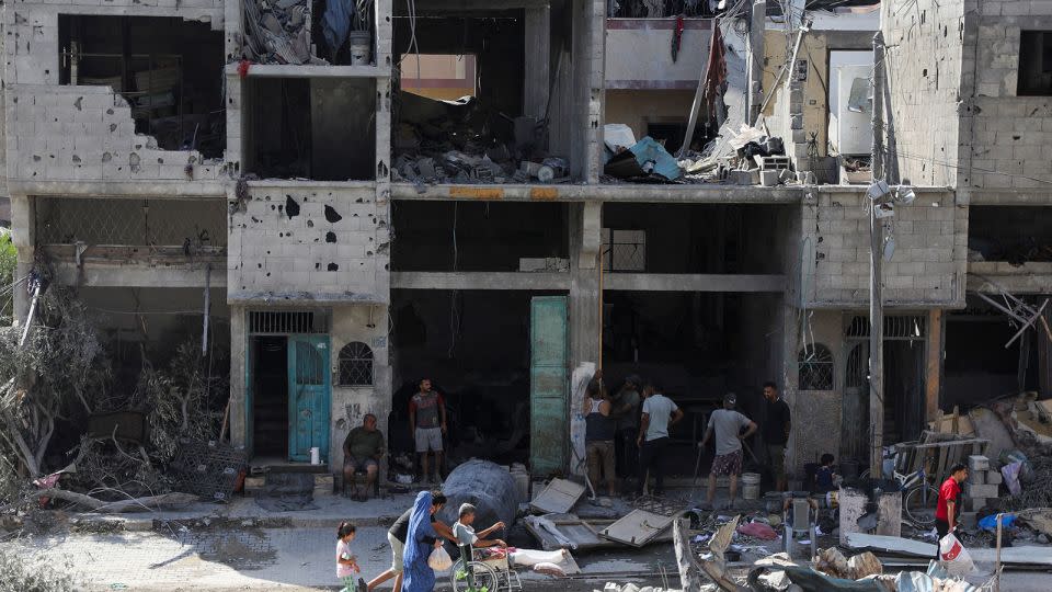 People walk through the rubble, following Israeli attacks on the area where Israeli hostages were rescued on Saturday, in the Nuseirat refugee camp in central Gaza, on Sunday, June 9.  - Abed Khaled/Reuters