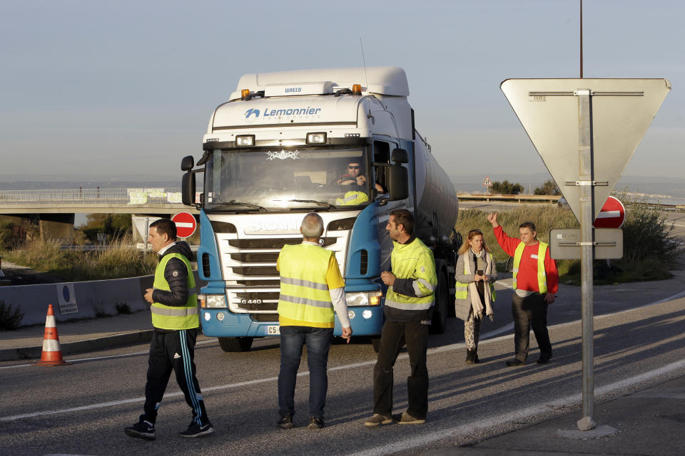 A group of demonstrators wearing their yellow vest occupy a traffic circle, Wednesday, Dec. 5, 2018 outside La Mede oil refinery, near Martigues, southeastern France. Trade unions and farmers pledged Wednesday to join nationwide protests against President Emmanuel Macron, as concessions by the government failed to stem the momentum of the most violent demonstrations France has seen in decades. (AP Photo/Claude Paris)