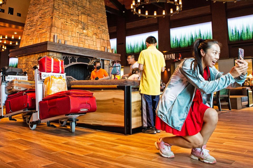 A visitor takes photos in the Grand Lobby during the grand opening of the Great Wolf Lodge in Perryville, Md., Thursday, June 29, 2023.