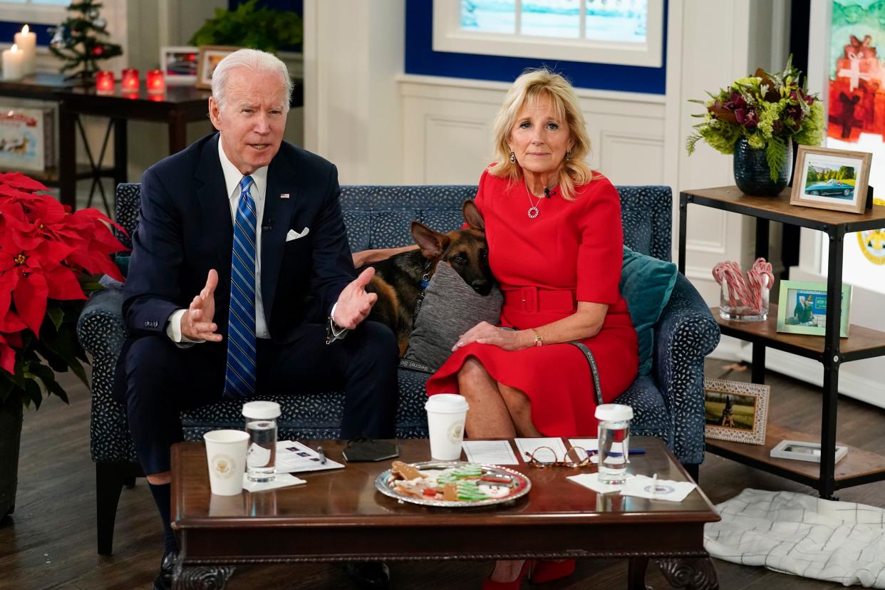 President Joe Biden, First Lady Jill Biden and their new dog Commander, a purebred German shepherd puppy, meet virtually with service members around the world on Saturday, Dec. 25, 2021, in the South Court Auditorium on the White House campus in Washington, to thank them for their service and wish them a Merry Christmas.