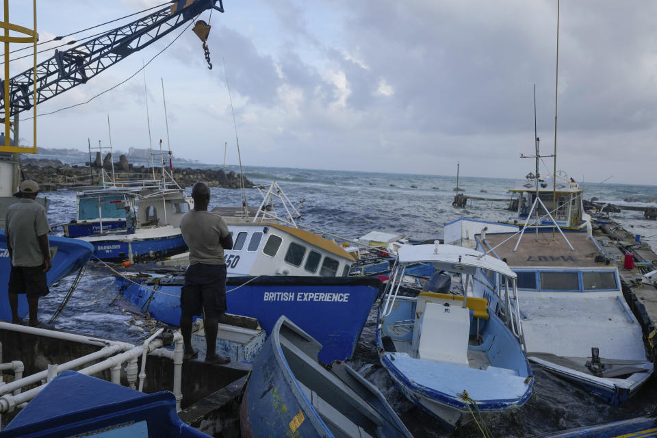 Fishermen look out at vessels damaged by Hurricane Beryl at the Bridgetown Fisheries in Barbados, Monday, July 1, 2024. (AP Photo/Ricardo Mazalan)