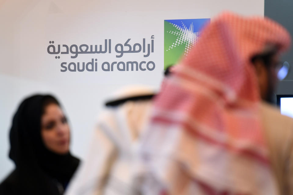 Saudi and Foreign investors stand in front of the logo of Saudi state oil giant Aramco. Photo: FAYEZ NURELDINE/AFP/Getty Images