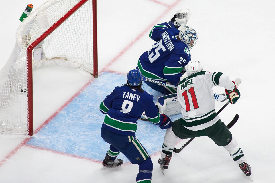 Vancouver Canucks goaltender Jacob Markstrom (25) gives up a goal to Minnesota Wild's Jared Spurgeon as Wild's Zach Parise (11) and Canucks defenseman Christopher Tanev (8) watch during the second period of an NHL hockey playoff game Sunday, Aug. 2, 2020, in Edmonton, Alberta. (Codie McLachlan/The Canadian Press via AP)