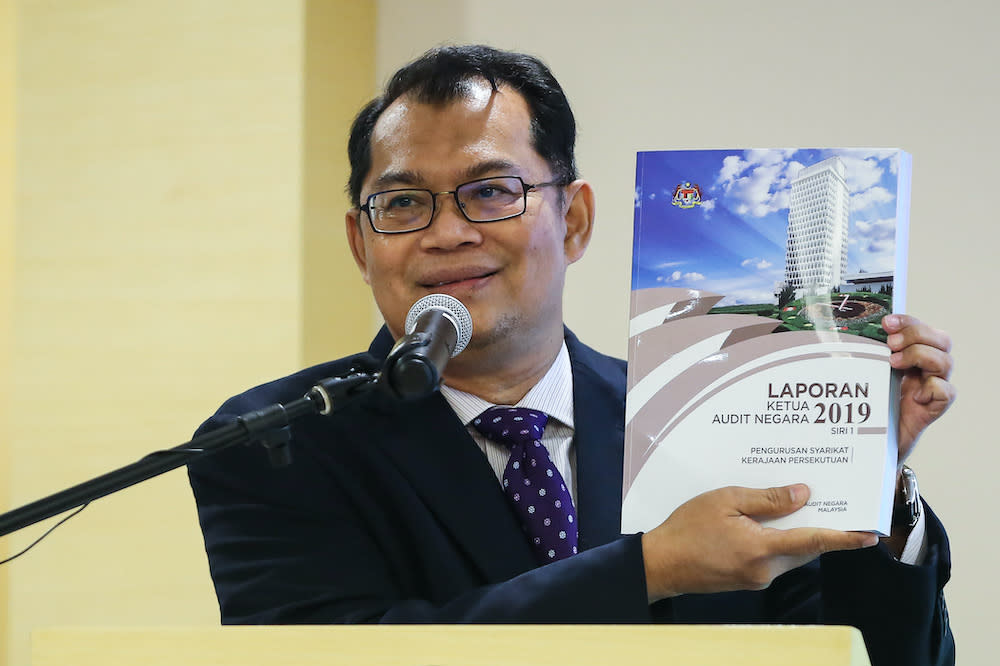 Auditor-General Datuk Nik Azman Nik Abdul Majid poses with a copy of the Auditor-General's 2019 Report in Putrajaya August 24, 2020. — Picture by Yusof Mat Isa