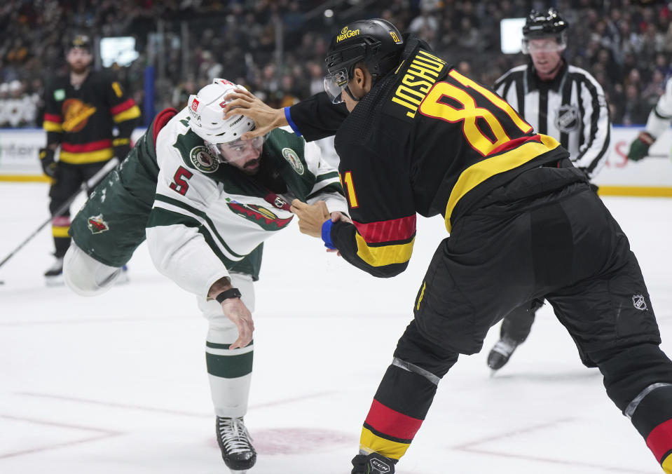 Minnesota Wild's Jacob Middleton, left, and Vancouver Canucks' Dakota Joshua fight during the second period of an NHL hockey game Thursday, Dec. 7, 2023, in Vancouver, British Columbia. (Darryl Dyck/The Canadian Press via AP)