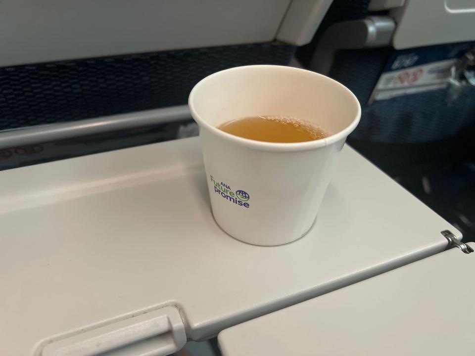 White cup of green tea in the cupholder.