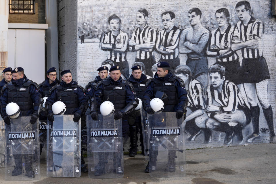 FILE - Serbian police officers guard Partizan stadium prior the Europa Conference League soccer match between Partizan and Feyenoord, in Belgrade, Serbia, on March 10, 2002. In the 90's, poverty surged, crime flourished and mafia-style killings flooded the streets. Inflation was the highest ever in the world, ordinary people lost their savings and jobs, while crime bosses and soccer hooligans rose to prominence. (AP Photo/Darko Vojinovic, File)