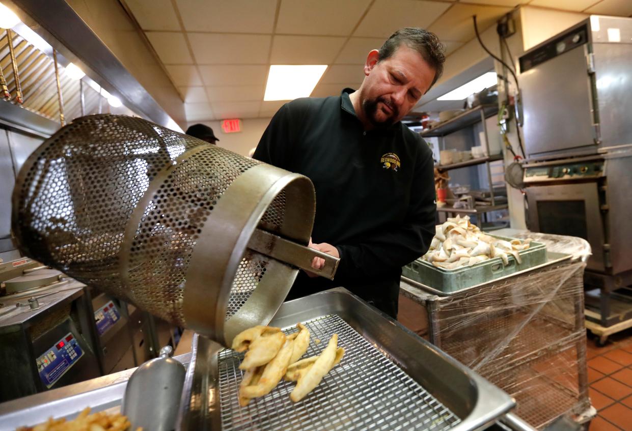 John Smits, owner of Redwood Inn, takes out a serving of perch from the fryer in 2022. He's been working in the kitchen since he was a 10-year-old broasting chicken.