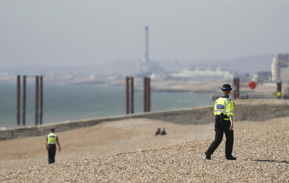 Police community support officers patrol Brighton beach, south England, Sunday April 5, 2020,as the UK continues in lockdown to help curb the spread of the coronavirus. The new coronavirus causes mild or moderate symptoms for most people, but for some, especially older adults and people with existing health problems, it can cause more severe illness or death. (Andrew Matthews/PA via AP)