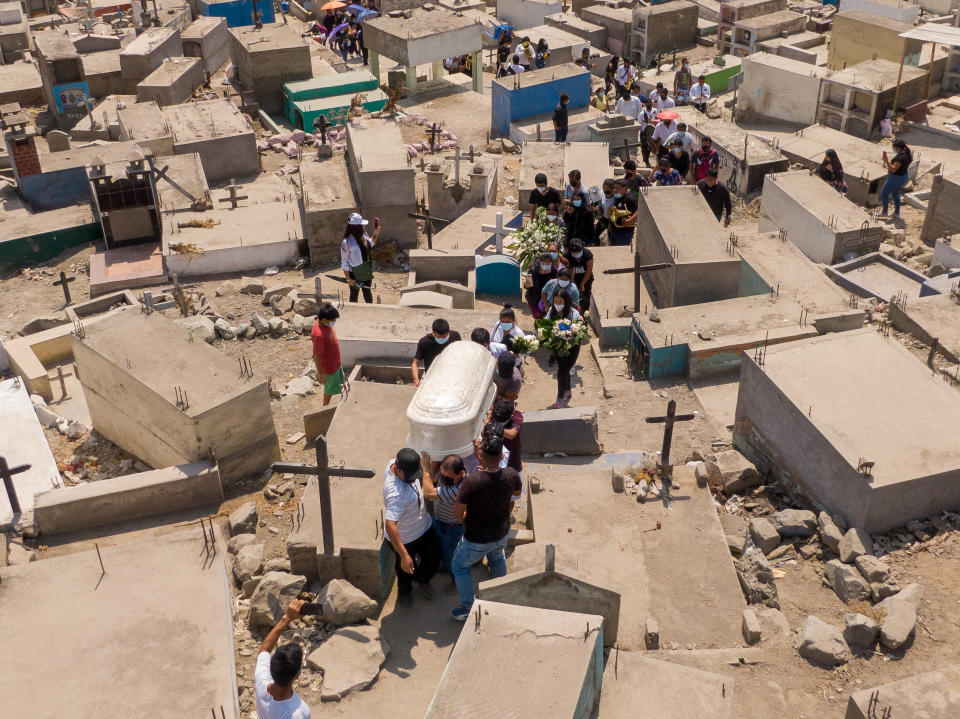 A coffin is seen being carried by people walking through 'Martires 19 de Julio' cemetery in April.