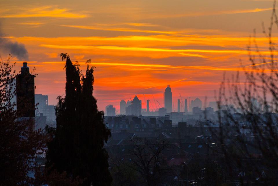 A colourful sky looms behind the London skyline this morning before the sun rises on what will be yet another warm day. Londoners will be enjoying the weather again today as high temperatures are set to continue in the capital. (Rex)