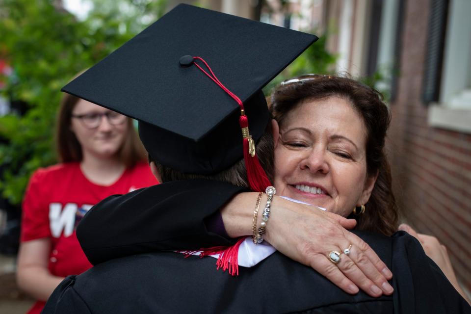 Louisville native Clay Harville, left, gets a hug from his mother, Mary Harville, before the start of the Topper Walk at Western Kentucky University. Harville is the first to graduate from WKUÕs autism program with a degree in special education teaching. May 11, 2019